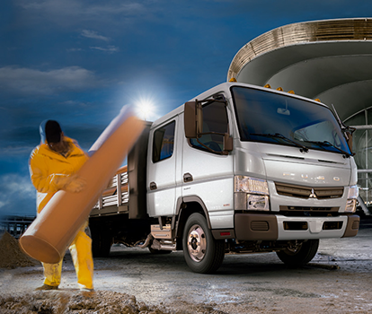 Camioneta Canter 715 DC Blanco, cargandon tubos de hormigones