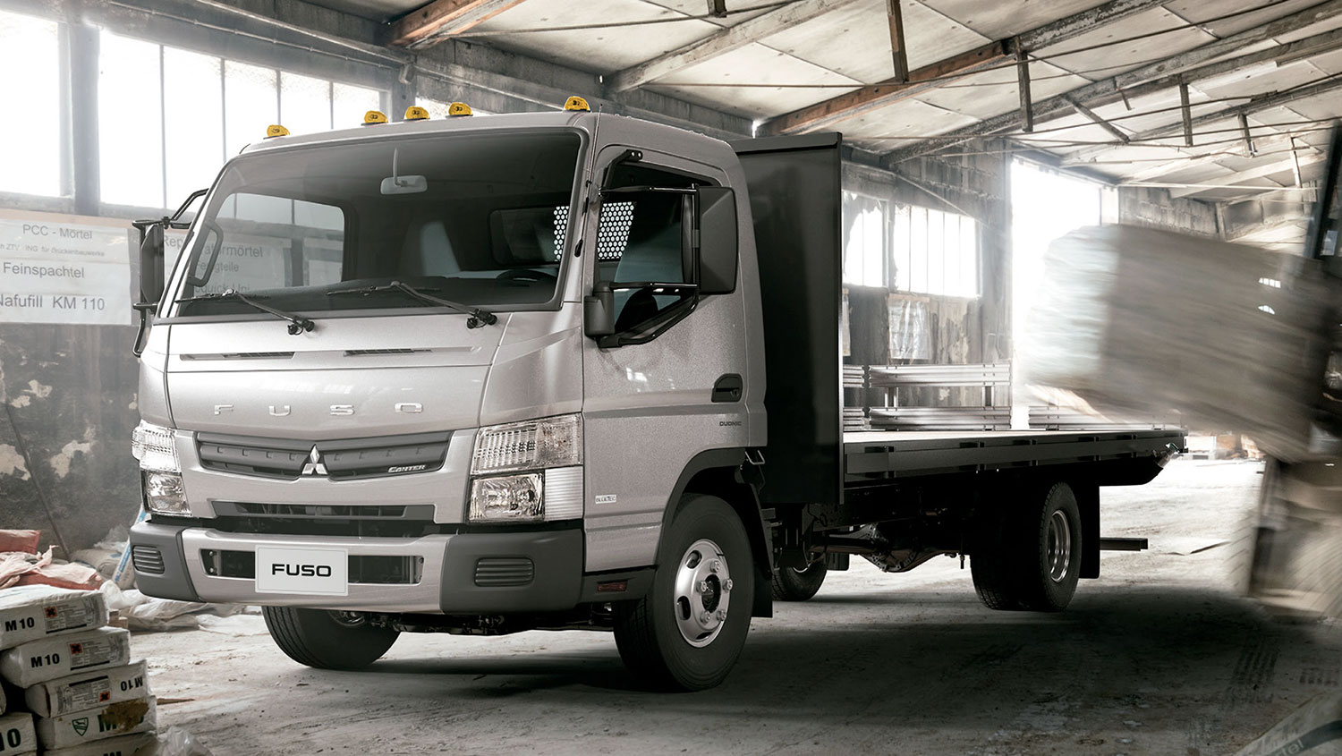 Camioneta Canter 513 Blanco, apartado en un taller de cemento listo para cargar el producto