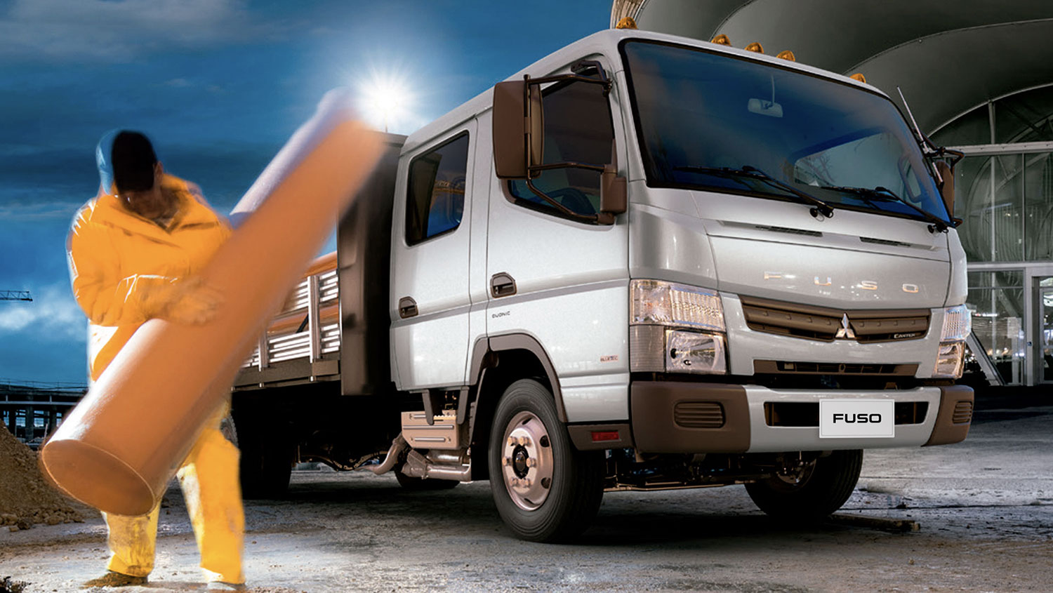 Camioneta Canter 715 DC Blanco, cargando tubos de hormigones