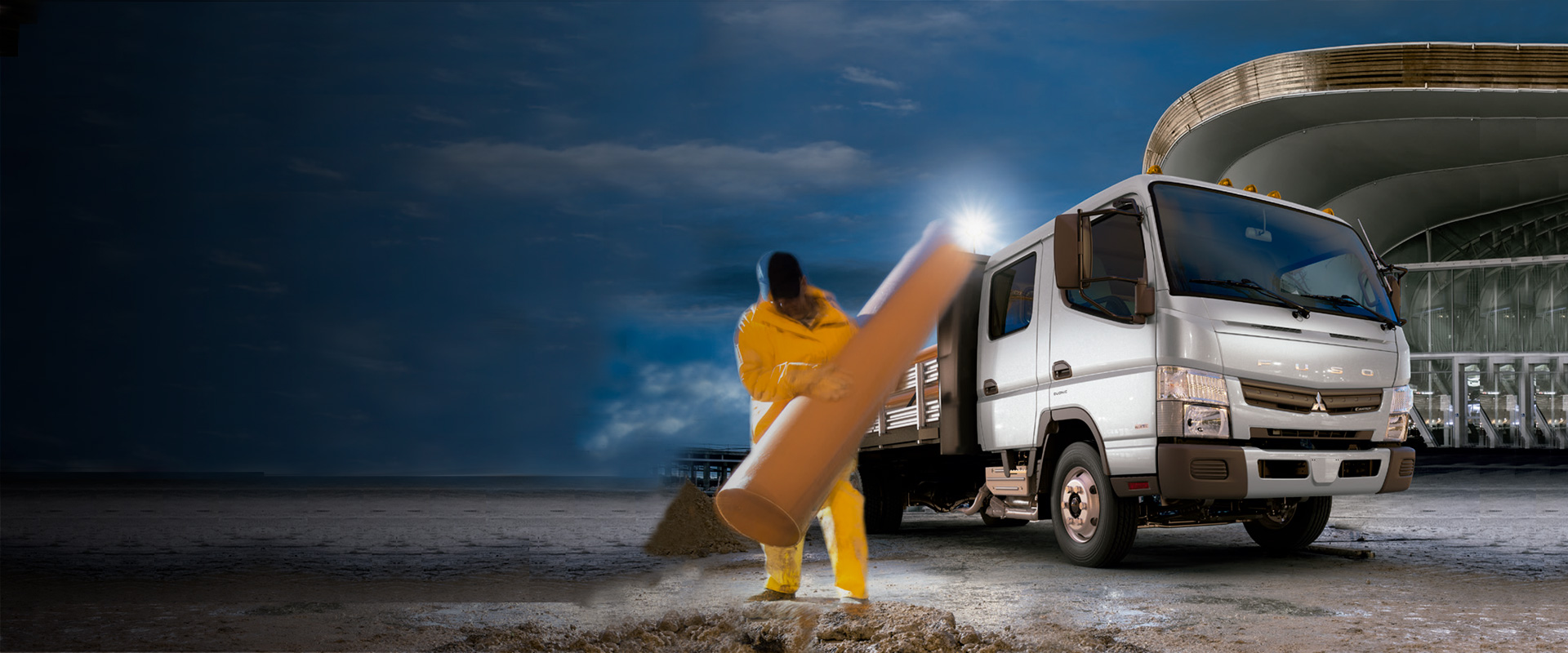 Camioneta Canter 715 DC Blanco, cargandon tubos de hormigones