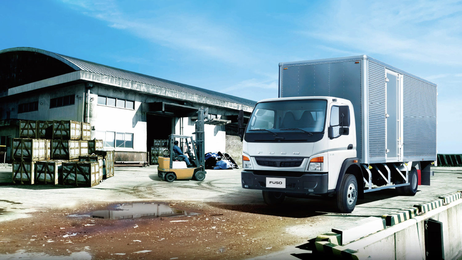 Camion Fuso 1017 Blanco, estacionado en la parte trasera de una fábrica