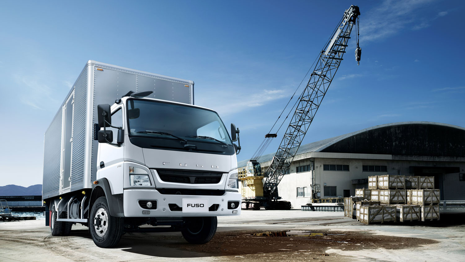 Camion Fuso 1017 Blanco, estacionado al lado de una fábrica cercano a una grúa
