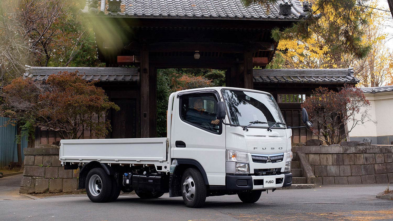 Camioneta Canter 413 Blanca, estacionada por delante de un jardín japonés