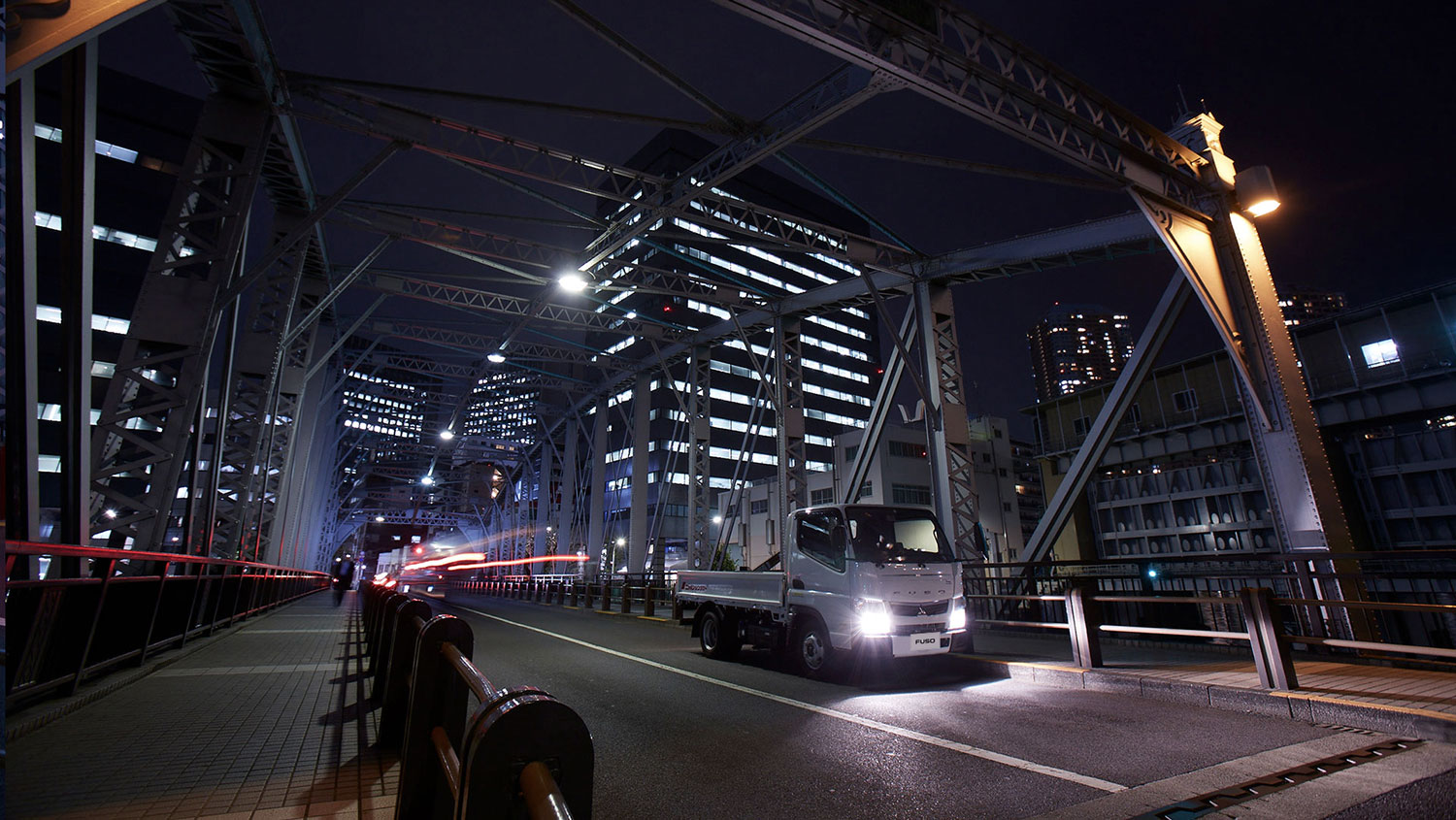 Camioneta Canter 413 Blanca, recorriendo las calles de una ciudad por la noche