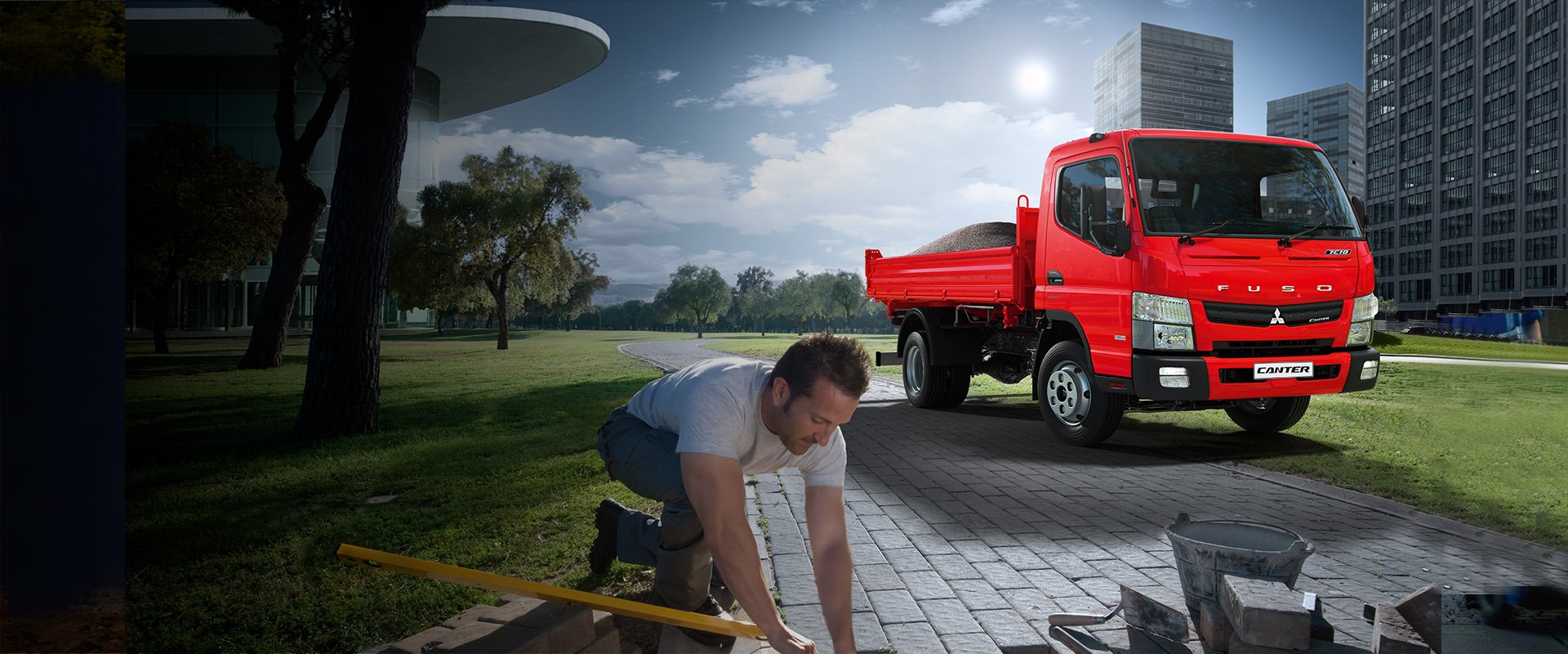 Camion Canter Fuso Rojo, situado al costado de un parque interurbano cargando cemento para la construcción de caminos