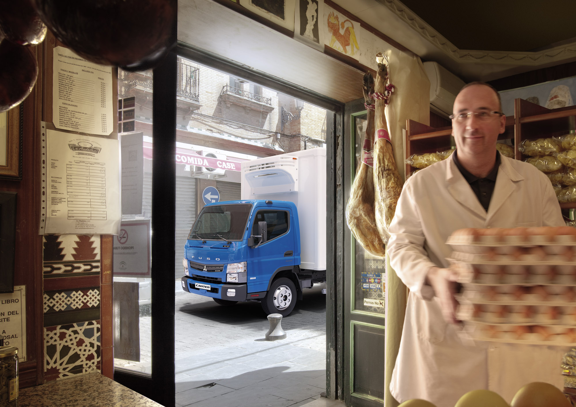 Trabajador entregando cajas de huevos a un negocio local, dejando estacionado su camion canter al frende del local