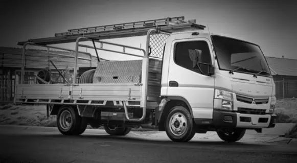 Hombre mirando el celular mientras pasa un camion fuso por detrás